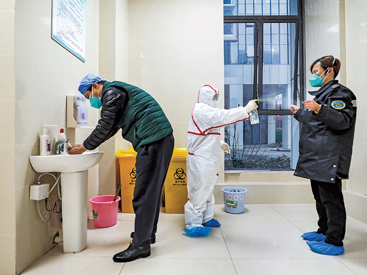 Lucrătorii medicali dezinfectează personalul ambulanței la un spital din Wuhan