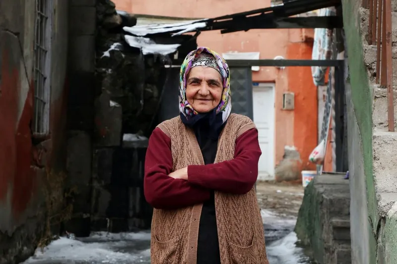 Femeie bătrână pozată în faţa casei sala sărăcăcioase - Foto: Pexels/Şahin Sezer Dinçer (Imagine cu caracter ilustrativ)