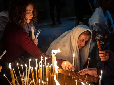 Pelerini creștini aprind lumânări în Biserica Sfântului Mormânt din Ierusalim - Foto: Profimedia Images