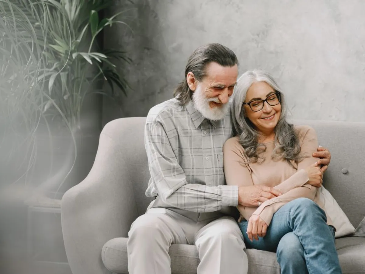 Cuplu fericit de seniori stând pe canapea şi vorbind - Foto: Freepik/prostooleh