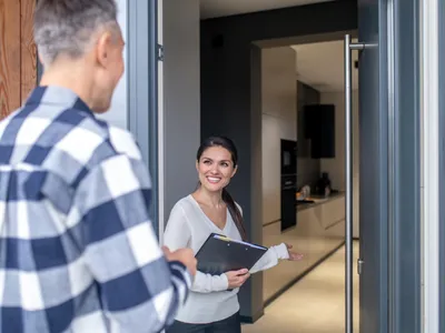 Femeie care a deschis ușa apartamentului - Foto: Magnific.com (Imagine cu rol ilustrativ)