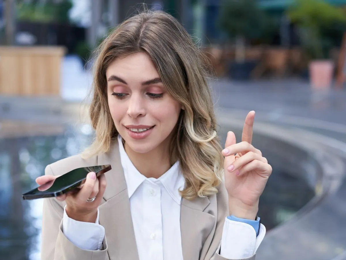 Femeie zâmbitoare făcând o operaţiune de banking prin telefonul mobil - Foto: Freepik/benzoix