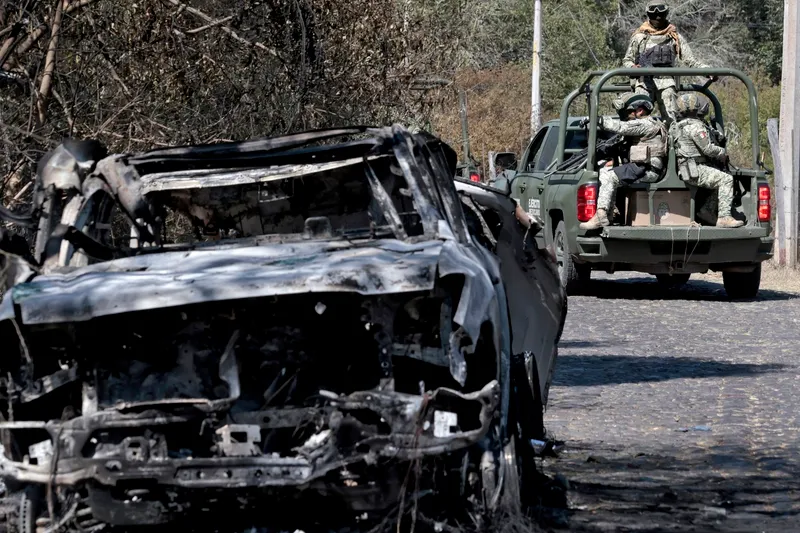 Militari mexicani l&acirc;ngă o mașină arsă folosită pentru a bloca drumul &icirc;n timp ce&nbsp; &bdquo;El Mencho&rdquo; &icirc;ncerca să fugă Foto: profimediaimages.ro