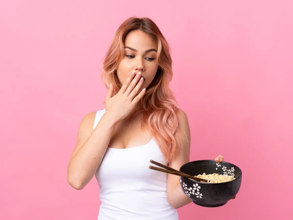 Femeie care are mâncare în mână - Foto: Freepik (Imagine cu rol ilustrativ)