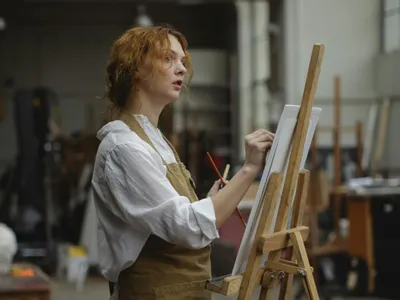 Tânără pictoriţă realizând o schiţă, pe şevalet - Foto: Pexels/cottonbro studio