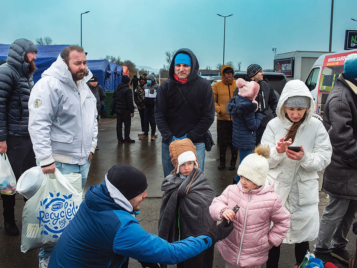 Familii de ucraineni cu copii în zona corturilor în care primeau apă și hrană la Isaccea.