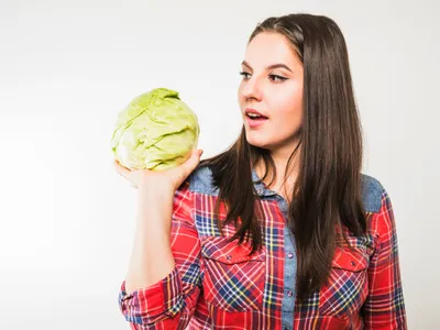 Femeie care ține o varză în mână - Foto: Freepik (Imagine cu rol ilustrativ)