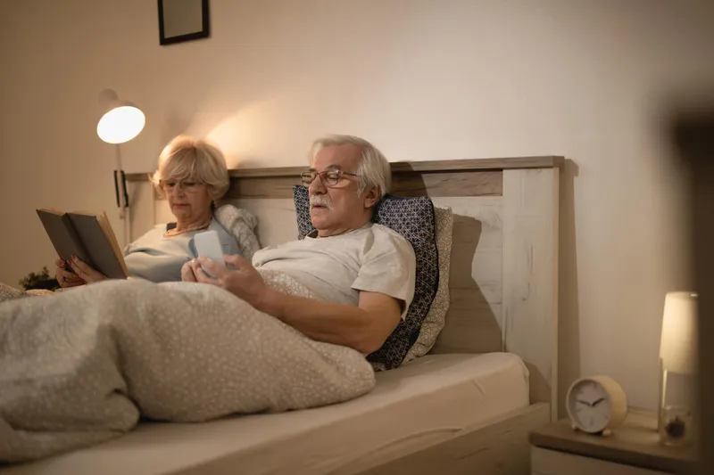Cuplu matur relax&acirc;ndu-se &icirc;n pat seara - Foto: Magnific.com (Imagine cu rol ilustrativ)