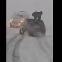 Un român s-a urcat pe un BMW pentru a-i crește „apăsarea” pe zăpadă. Șoferul va fi amendat - Foto: captură video