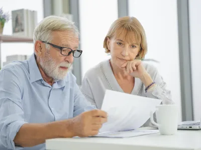 Pensionari citind hârtii la pensie - Foto: Freepik