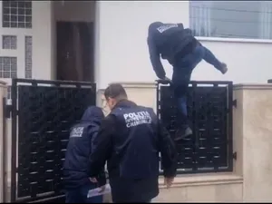 Un poliţist sare peste gardul lui Cătălin Cherecheş - Foto: captură video YouTube/Vasile Dale