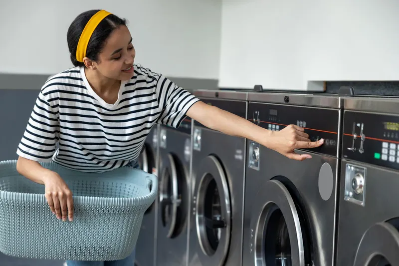 Femeie care pune la spalat rufe - Foto: Freepik (Imagine cu rol ilustrativ)