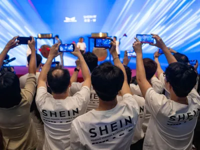 Angajaţi Shein, filmând şi pozând ceremonia de lansare a acţiunilor companiei, la Bursa din Hong Kong - Foto: Profimedia Images