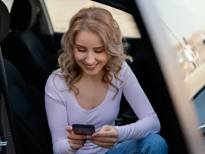 Femeie care stă pe telefon în mașină - Foto: Magnific.com (Imagine cu rol ilustrativ)