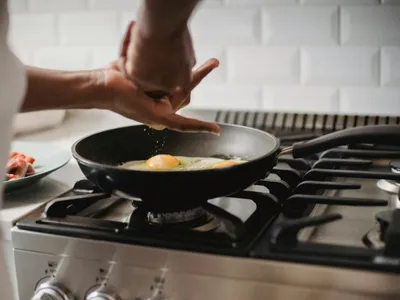 Persoană gătind la aragaz cu gaz metan - Foto: Pexels/Ketut Subiyanto