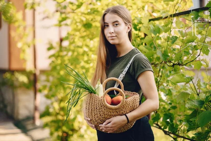 O femeie frumoasă lucrează &icirc;ntr-o grădină l&acirc;ngă casă - Foto: Magnific.com (Imagine cu rol ilustrativ)