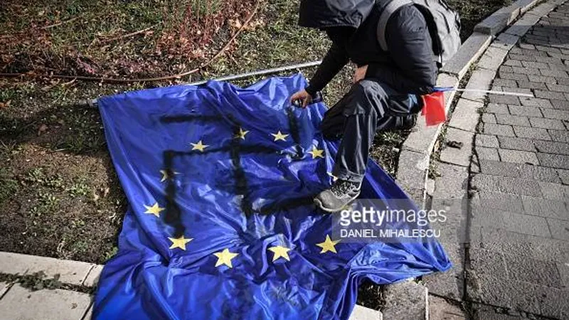 Protestatar AUR desenează svastica pe steagul UE. Sursă imagine: AFP, Daniel Mihăilescu/ Getty Images