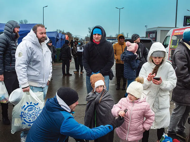 Familii de ucraineni cu copii în zona corturilor în care primeau apă și hrană la Isaccea.