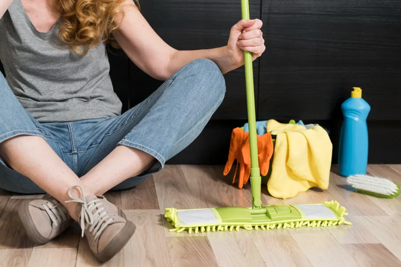 Femeie care ține un mop - Foto: Magnific.com (Imagine cu rol ilustrativ)
