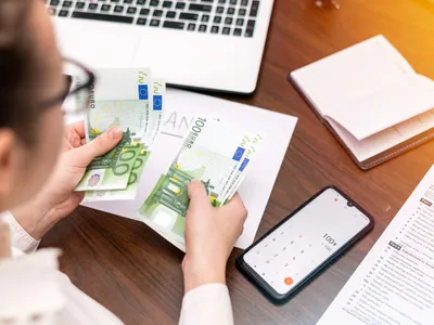 O angajată numără banii din salariu - Foto: Freepik (rol ilustrativ))