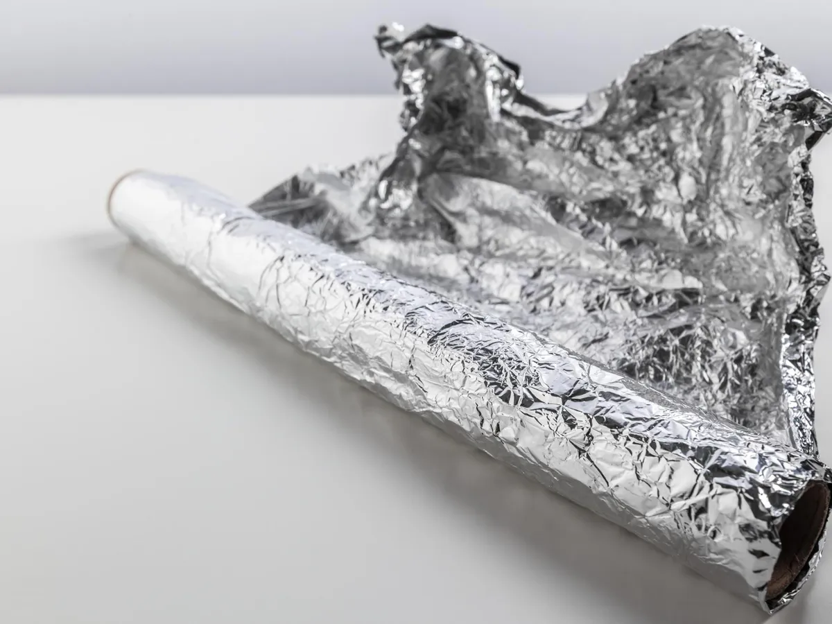 Rolă de folie de aluminiu izolată pe fundal alb - Foto: Magnific.com (Imagine cu rol ilustrativ)