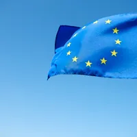 Fluturând steagul Uniunii Europene pe fundal albastru - Foto: Magnific.com (Imagine cu rol ilustrativ)