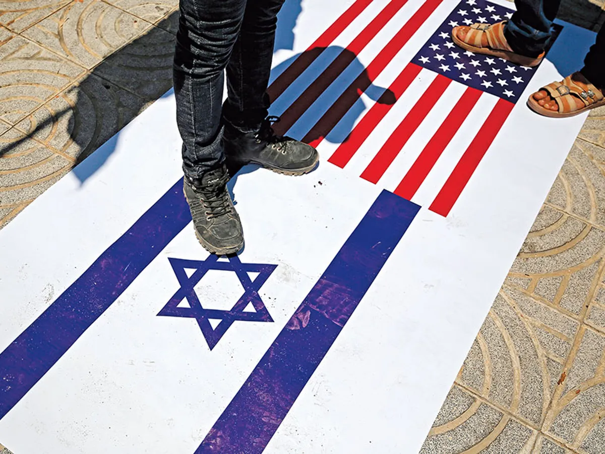 Un poster cu steaguri israeliene și americane este călcat de susținătorii palestinieni ai grupării Al-Ahrar în Rafah