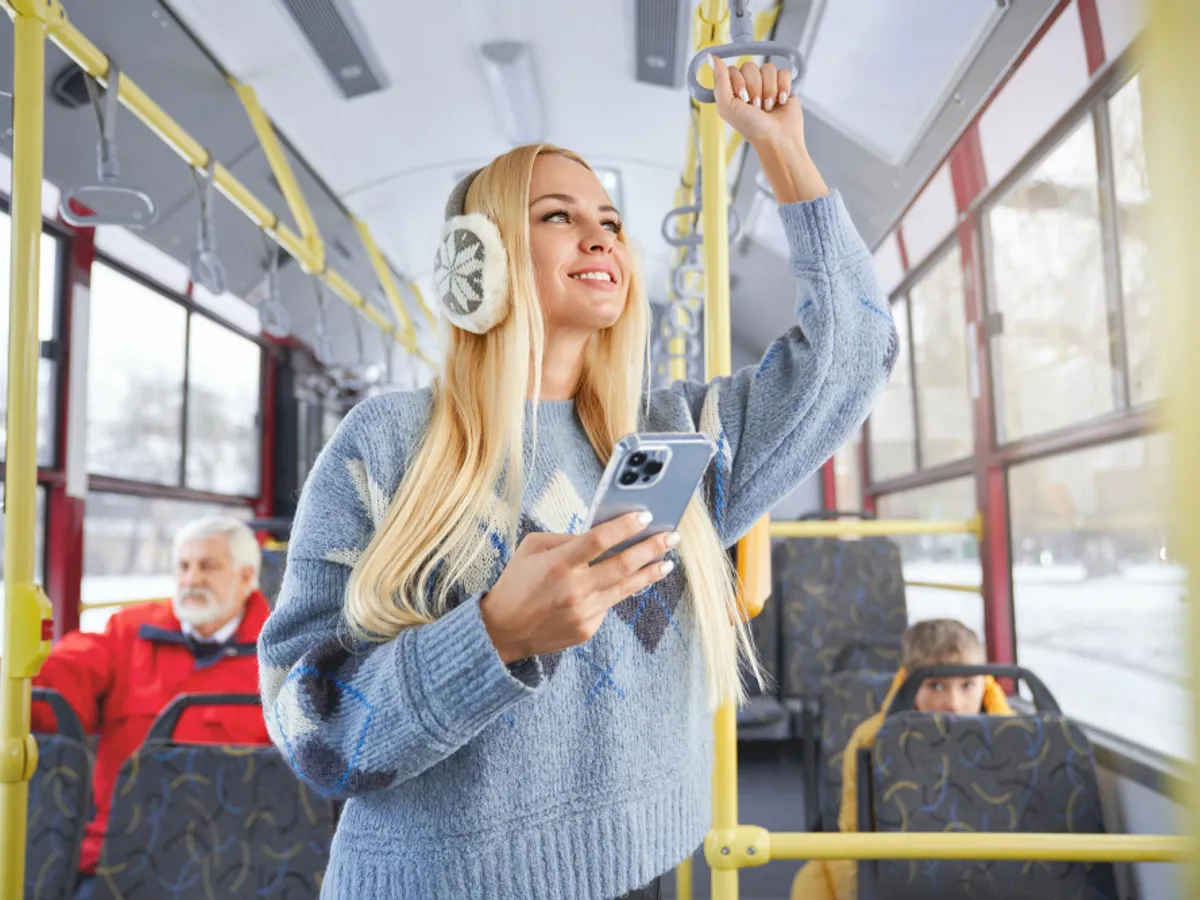 O femeie ascultă muzică la cățti în autobuz - Foto: magnific (rol ilustrativ)
