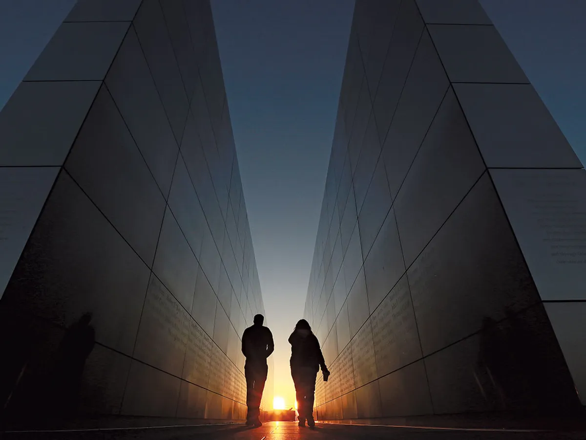 Oamenii merg prin Memorialul Cerului Gol 9/11 din Liberty State Park, New Jersey