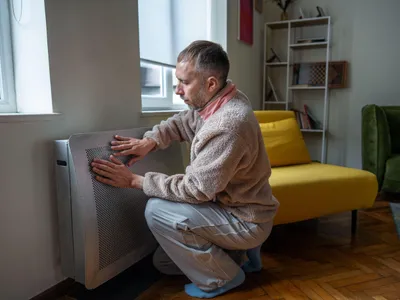 Bărbat care se încălzește la calorifer - Foto: Profimedia Images (Imagine cu rol ilustrativ)