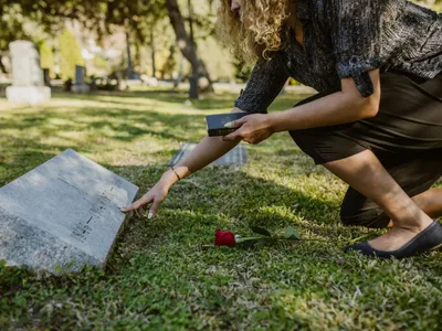 Femeie cinstindu-şi ruda, laa mormânt - Foto: Pexels/RDNE Stock Project