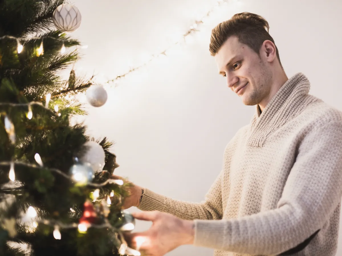 Bărbat care pun globuri în brad - Foto: Freepik (Imagine cu rol ilustrativ)