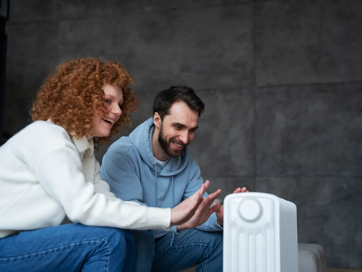 Cuplu care se încălzește la un calorifer - Foto: Freepik (imagine cu rol ilustrativ)