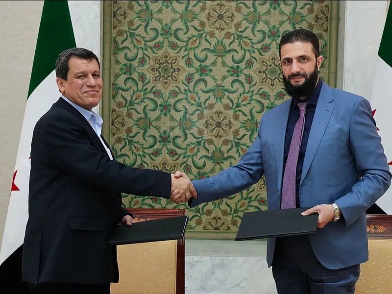 Președintele interimar al Siriei Ahmed al-Sharaa (dr) și comandantului șef al Forțelor Democratice Siriene (SDF), Mazloum Abdi, după semnarea acordului istoric - Foto: Profimedia Images