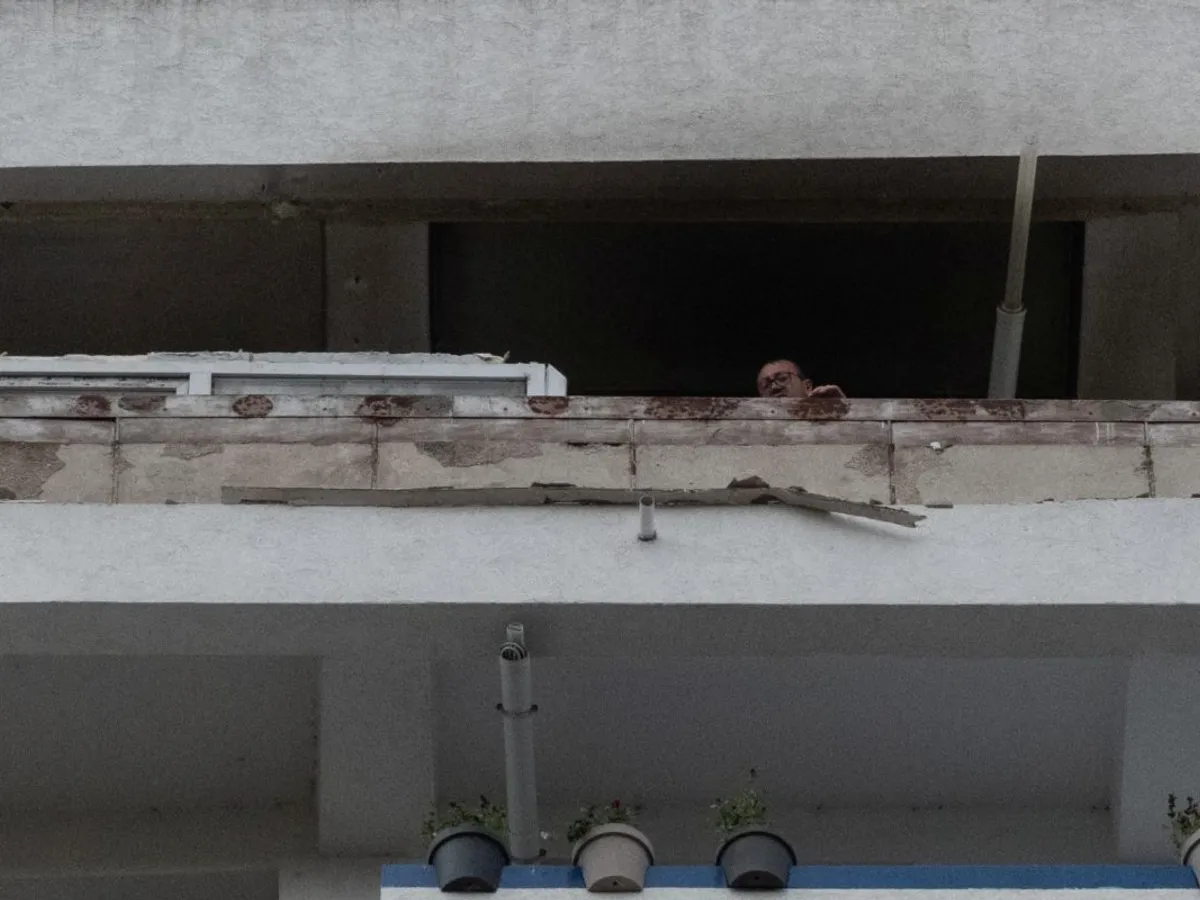 Un locatar se uită în jos, de la balcon, din Blocul Stirex, din centrul Galaţiului, lovit de o dronă rusească - Foto: INQUAM PHOTOS (Imagine cu caracter ilustrativ)