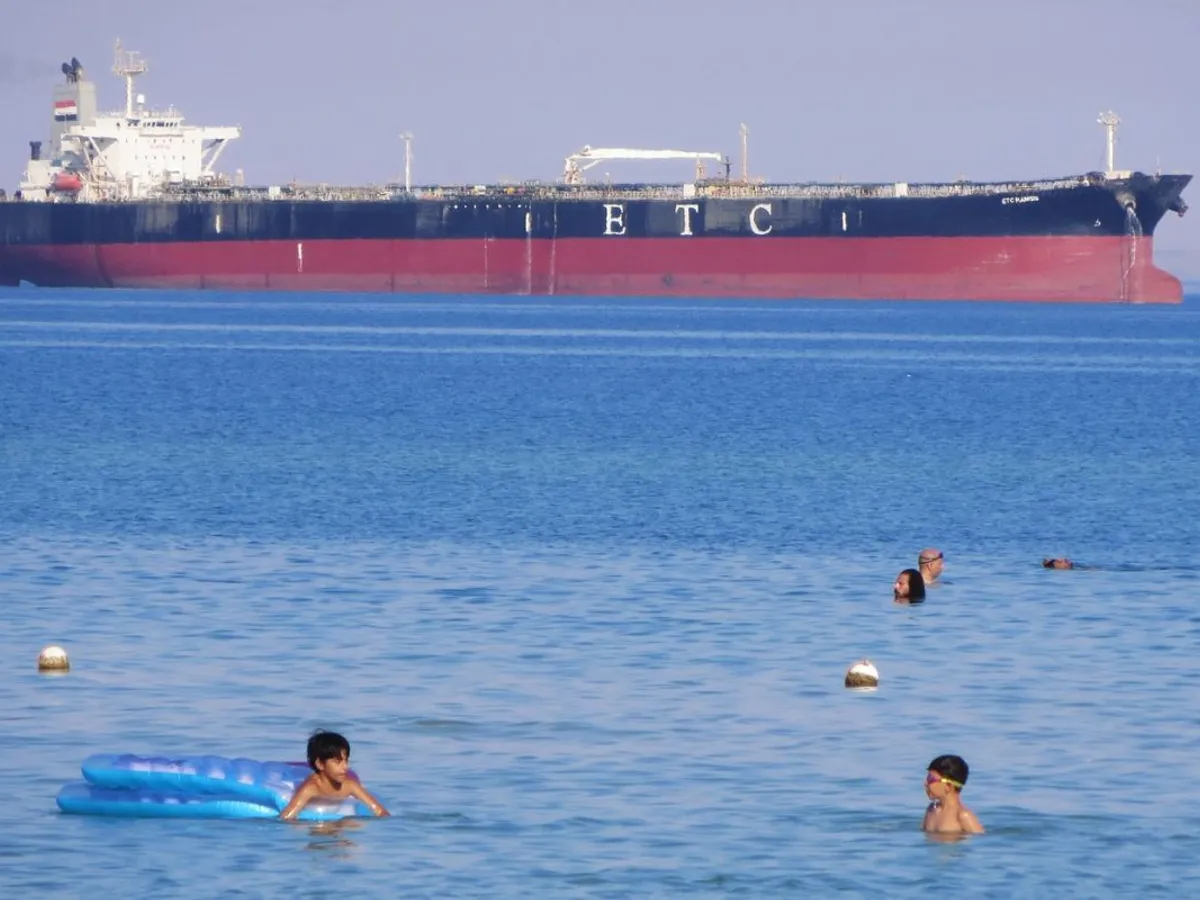 Egiptenii aflaţi în vacanţă înoată în apele Golfului Suez, lângă petrolierul ETC Ramsis - Foto: Profimedia Images
