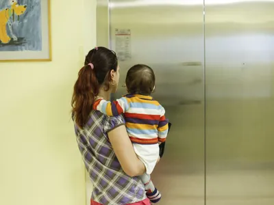 O mamă aşteaptă să urce în lift - Foto: INQUAM PHOTOS/Octav Ganea