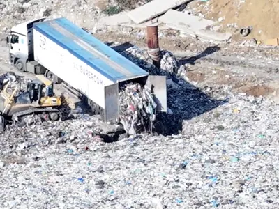 Un TIR al Supercom descarcă deșeuri într-o groapă săpată în groapa de gunoi de la Bârcea Mare. Sursă foto: youtube.com
