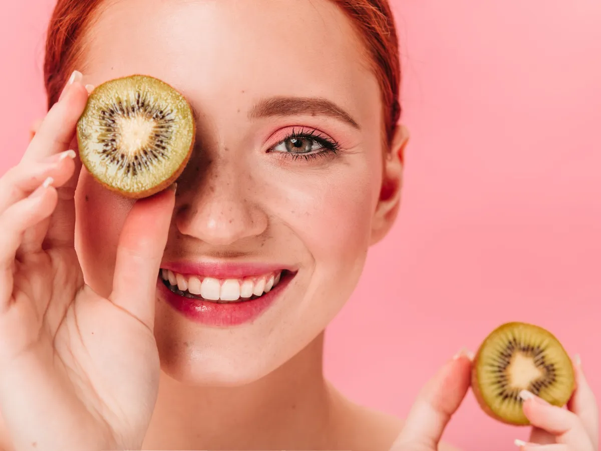 Femeie cu kiwi în mână - Foto: Magnific.com (Imagine cu rol ilustrativ)