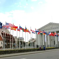 O femeie și copiii ei se plimbă pe lângă steagurile țărilor NATO înainte de o întâlnire a miniștrilor de externe NATO pe o piață principală din orașul vechi din Vilnius - Foto: Profimedia Images