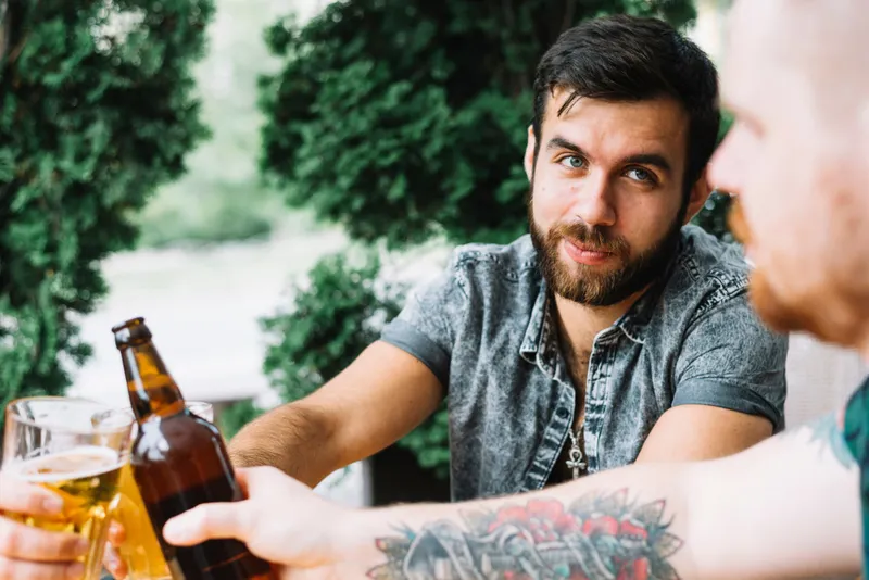 Bărbați care ciocnesc sticlele cu alcool - Foto: Freepik (imagine cu rol ilustrativ)