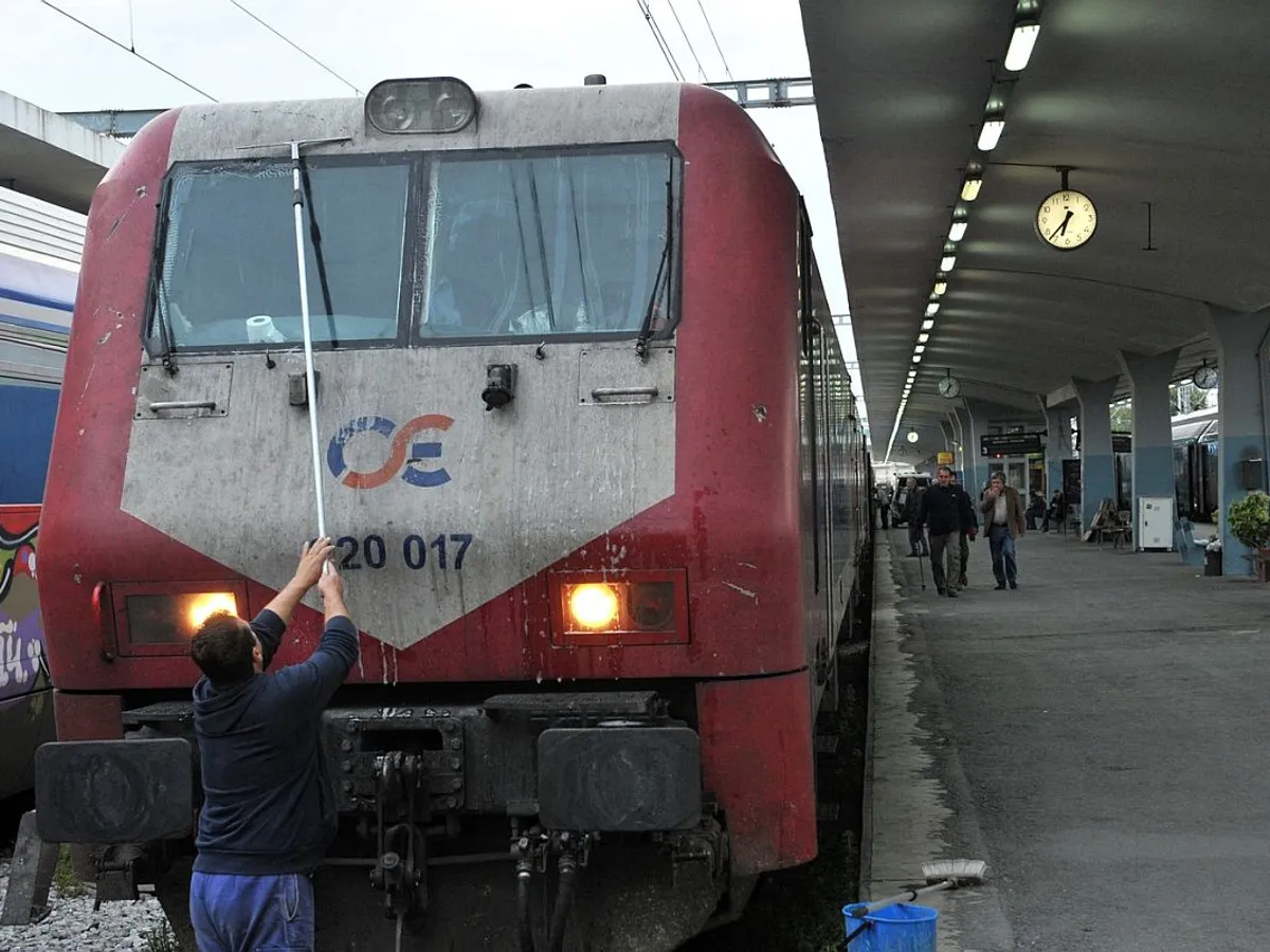 Un bărbat curăţă faţa locomotivei trenului care pleacă din Salonic, spre Sofia - Foto: Profimedia Images