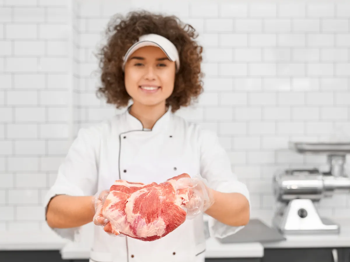 Femeie cu o bucată de carne - Foto: Magnific.com (Imagine cu rol ilustrativ)