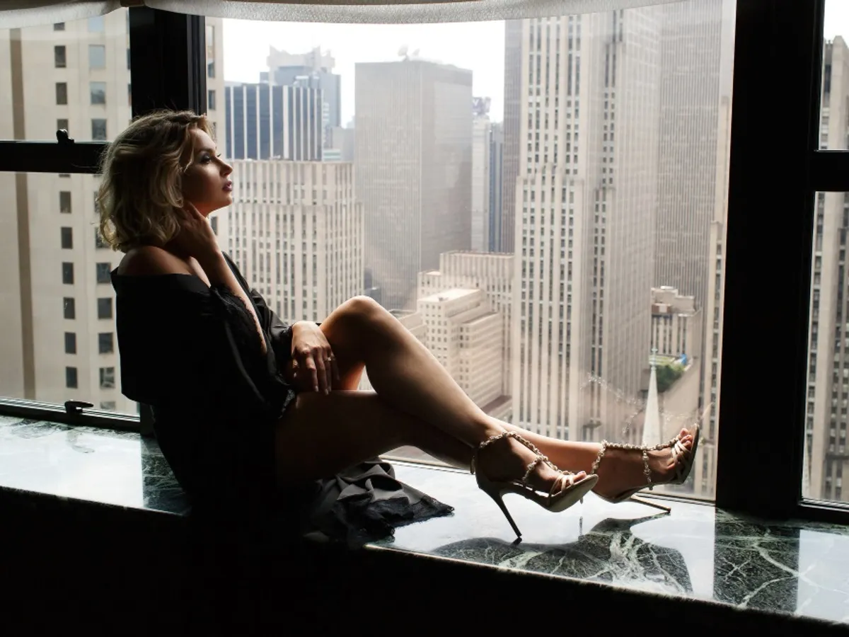 Femeie la geam - Foto: Freepik