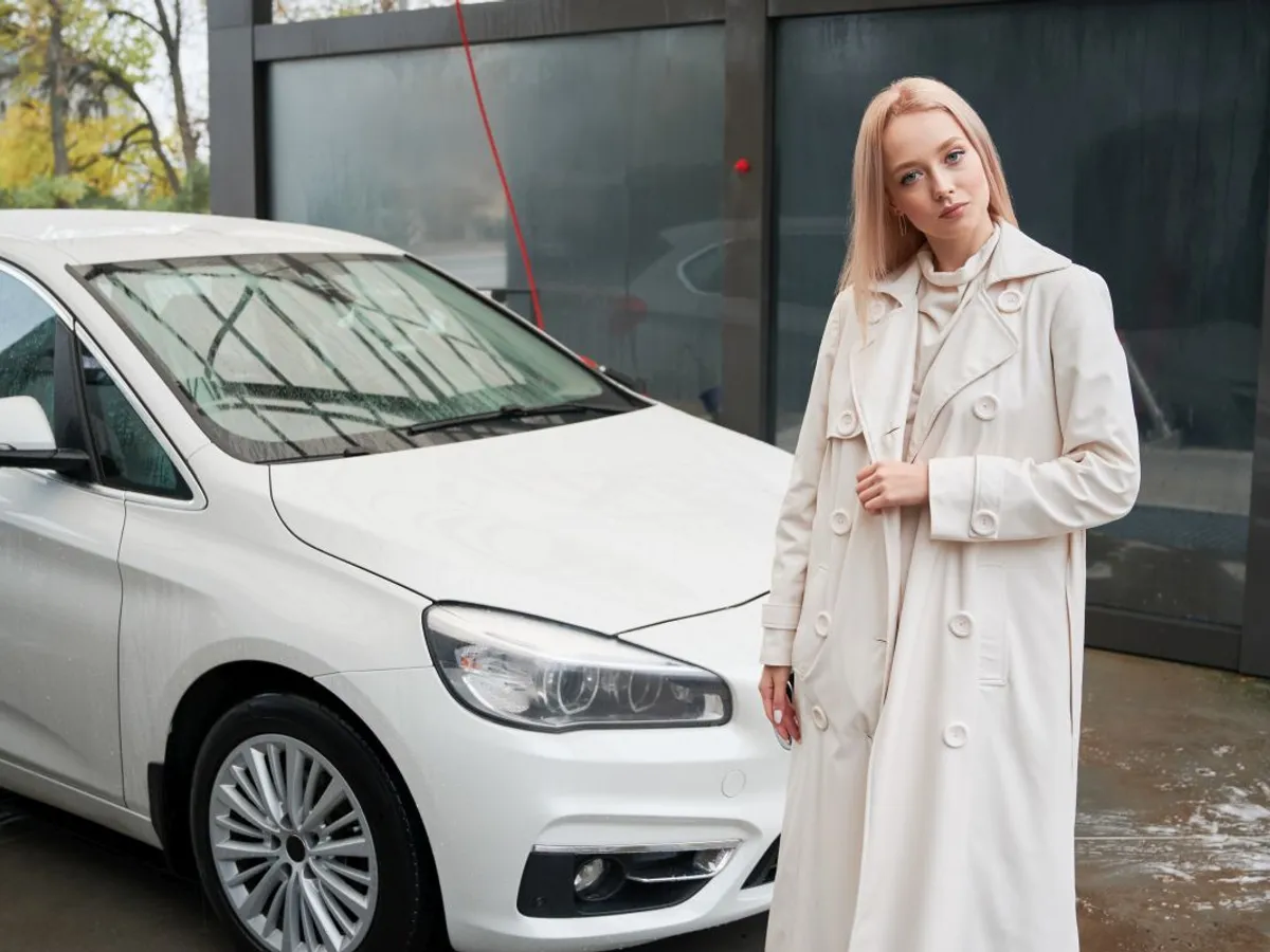 Femeie stând în faţa unei maşini parcate - Foto: Magnific.com/ArtPhoto_studio