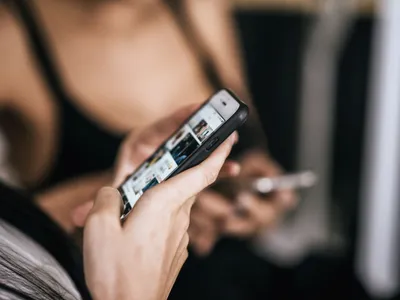Femeie uitându-se pe TikTok, pe smartphone - Foto: Magnific.com/jcomp