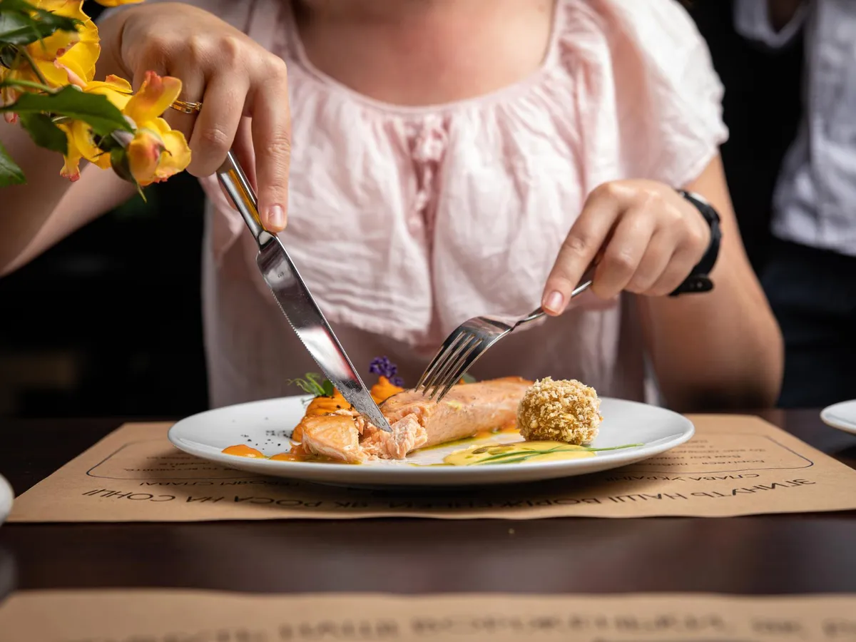 Persoană care mănâncă pește - Foto: Freepik (Imagine cu rol ilustrativ)