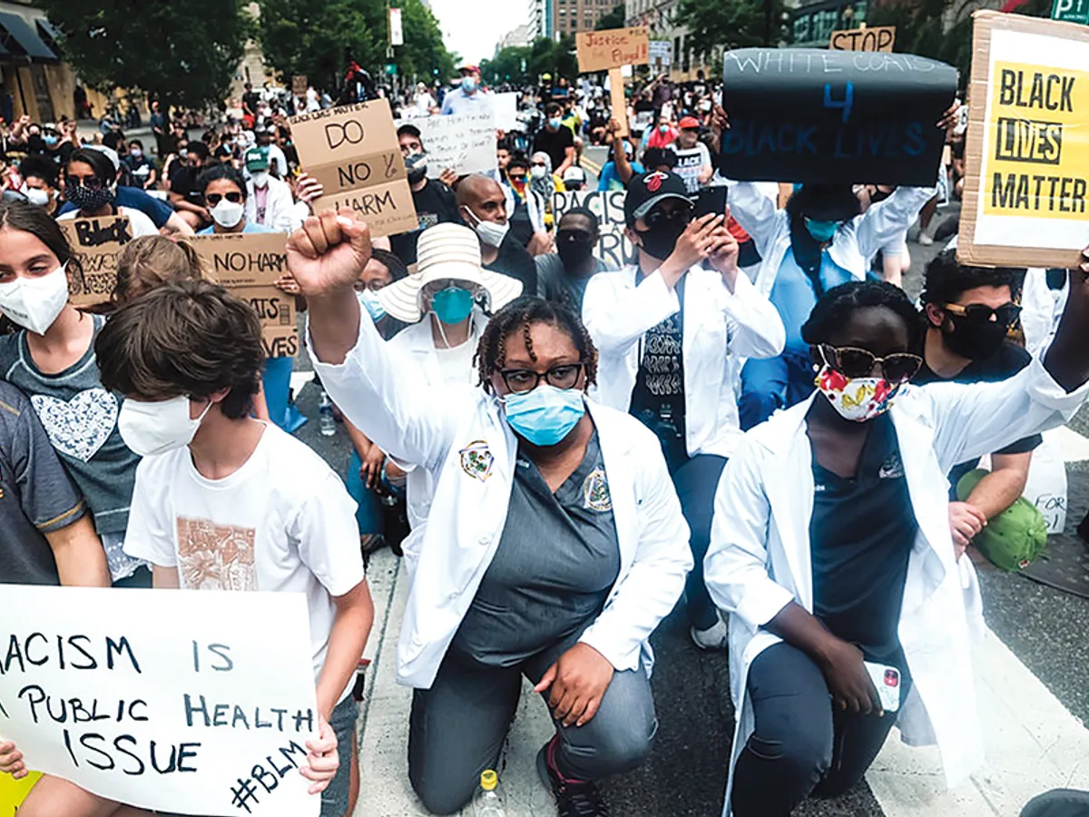 În Washington, lucrători în domeniul sanitar, în prima linie în lupta cu COVID-19, îngenunchează alături de protestatari