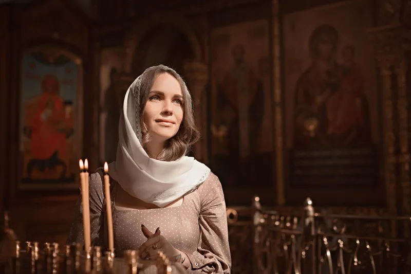 T&acirc;nără femeie din Biserica Ortodoxă aprinde lum&acirc;nări - Foto: Magnific.com (Imagine cu rol ilustrativ)