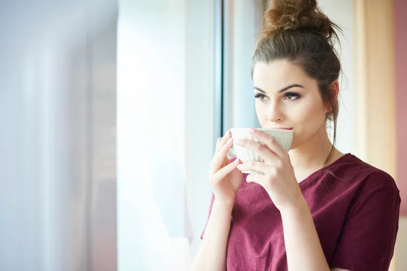 Femeie frumoasă care bea o ceașcă de cafea - Foto: Freepik